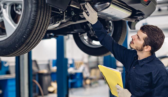 Professional worker inspecting a car in the auto workshop