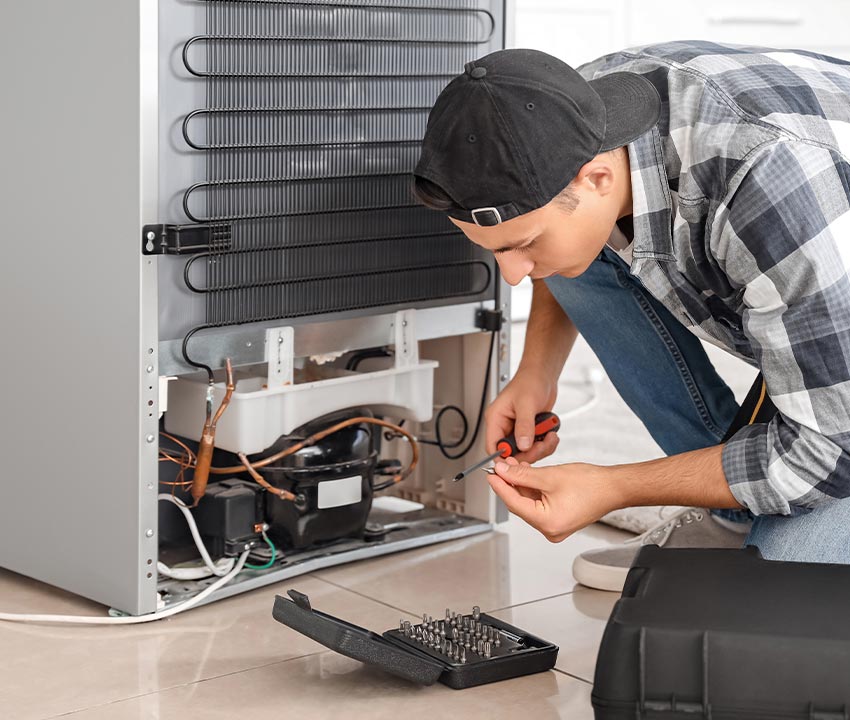 Professional worker fixing refrigerator